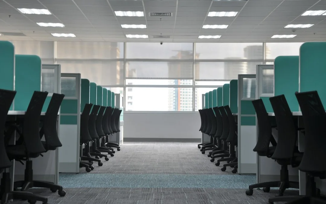 Turkuaz bölmeli çalışma masaları sıra sıra dizilmiş boş ofis katı