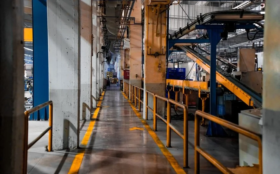 İki yanındaki makineler arasında uzanan fabrika içi geçiş koridoru