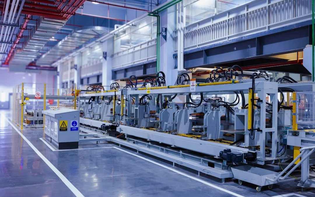 Mavi ışık altında parlayan, robot kollu modern üretim hattı